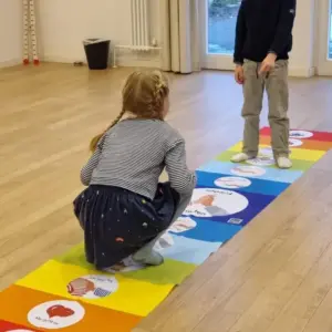 2 Kinder auf dem Friedensteppich mit Symbolen